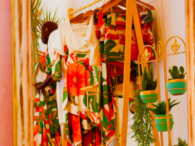 Rack of vibrant clothing with potted plants