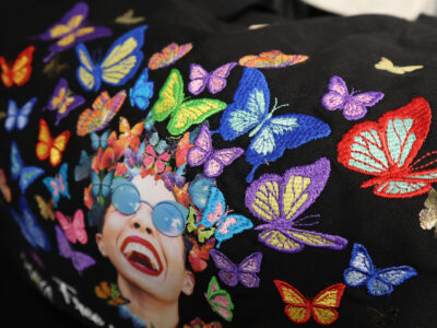 Black Tote bag with face of a woman and embroidered butterflies using Melco Embroidery Machine