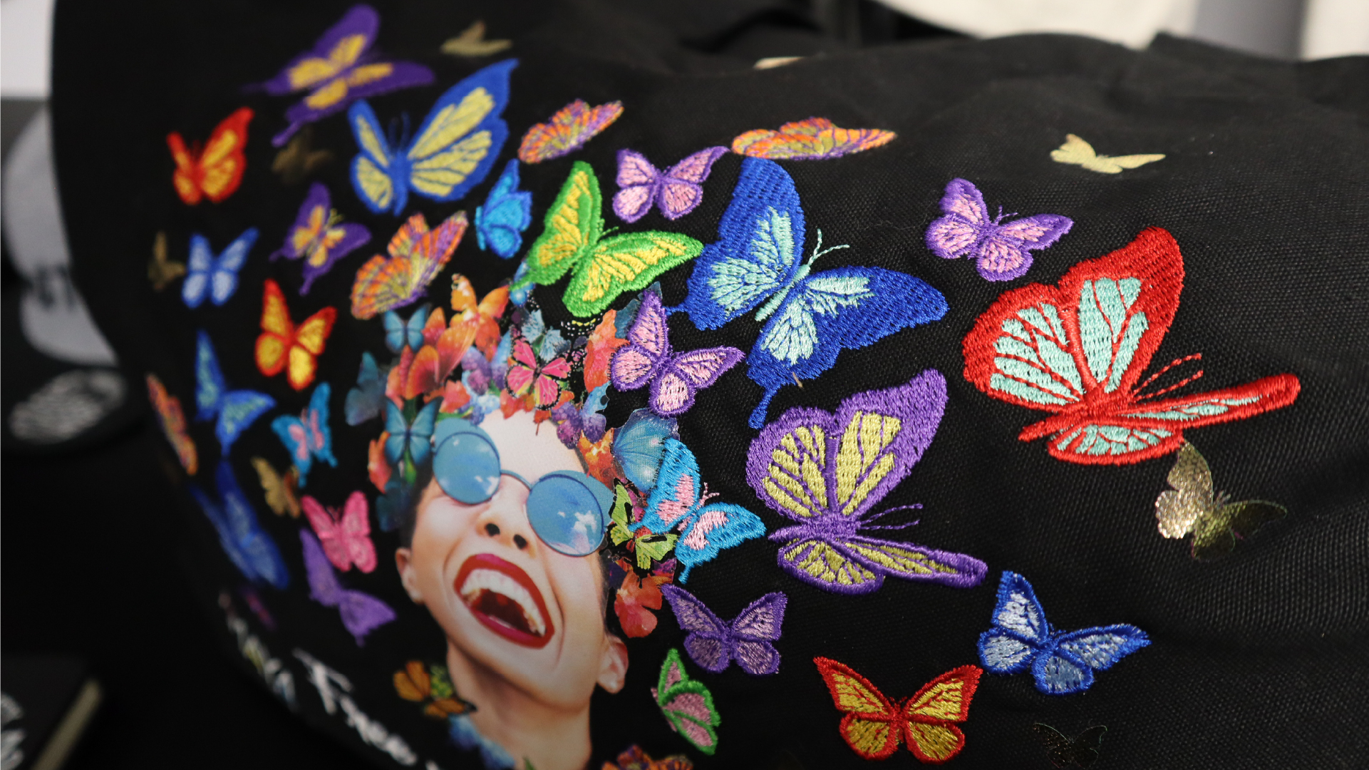 Black Tote bag with face of a woman and embroidered butterflies using Melco Embroidery Machine