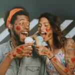 Two people sharing ice cream, covered in tattoos using Forever Tattoo Paper