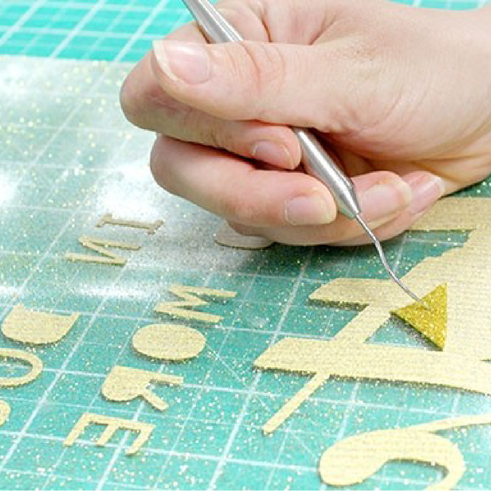 Gold glitter transfer being weeded using Sef Glitterflex Paper